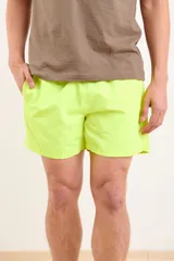 Short de baño verde lima, de corte clásico y tiro medio, con cordón ajustable en la cintura.
