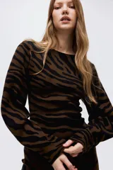 Vestido corto de punto jacquard suave, con estampado de cebra en tonos marrón y negro. Presenta un corte ajustado al cuerpo y mangas largas.