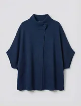 Capa tejida color fucsia, con cuello alto abotonado y mangas cortas estilo japonesa. Tejido de punto grueso.