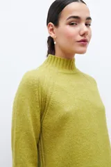 Polera de punto color verde pistacho, de corte holgado y cuello alto.