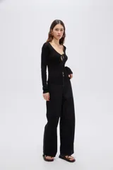 Top de manga larga en tejido de punto con lurex, color negro, de corte ajustado al cuerpo, con escote en V pronunciado y cierre delantero mediante finos lazos para anudar.