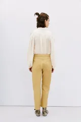 Pantalon de corte recto confeccionado en cuero ovino con acabado metalizado en color plata. Presenta cierre frontal con cremallera y bolsillos laterales.