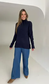 Polera de tejido de punto color azul, con cuello alto, mangas largas y tajos laterales en el ruedo.