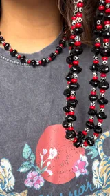 Collar compuesto por piedras ágata DZI, cuentas de vidrio y cristal checo en color negro y rojo, con cadena metálica en los extremos.