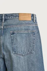 Jeans regular fit de mezclilla negra con efecto lavado, corte recto y tiro medio. Cuenta con diseño de cinco bolsillos y cierre frontal con cremallera y botón.
