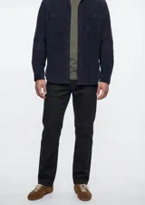 Pantalón de sarga de corte ajustado, color verde oscuro, con diseño clásico de cinco bolsillos y cierre frontal con botón y cremallera.