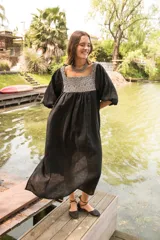Túnica de lino color crudo con corte holgado y mangas abullonadas con elástico. Presenta una pechera frontal y trasera con estampado étnico en tonos terracota y amarillo.