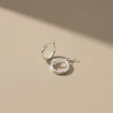 Par de aros tipo argolla clásica fabricados en plata 925, con diseño minimalista y cierre de perno a presión.
