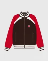 Campera de tejido de punto de grosor medio, con cuerpo marrón oscuro, mangas rojas y detalles en blanco en los hombros, cuello y puños. Presenta cierre frontal y un pequeño logo bordado en el pecho.