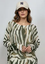 Sweater liviano de tejido de punto con estampado abstracto en tonos verde, beige y marrón. Presenta cuello redondo, corte holgado y mangas largas.