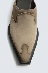 Zueco de piel con acabado serraje, diseño de punta cuadrada y suela de goma a contraste con tacón bajo.