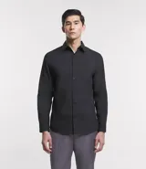 Camisa de corte regular confeccionada en microfibra, con cuello inglés, manga larga y cierre frontal abotonado. Presenta un diseño liso y minimalista, ideal para un estilo formal o de oficina.