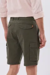 Bermuda cargo color azul marino, de gabardina con bolsillos laterales con solapa en las piernas y presillas para cinturón. Incluye cinturón de lona trenzada oscura con detalles en cuero sintético y hebilla metálica.