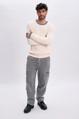 Pantalón jean cargo de corte recto en color gris claro, con bolsillos laterales en las piernas.