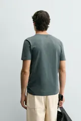 Camiseta de corte ajustado confeccionada en tejido de algodón con elasticidad, cuello redondo y manga corta.