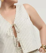 Blusa sin mangas, estilo chaleco, confeccionada en viscolino con estampado de rayas verticales finas. Presenta escote en V con amarras ajustables en el centro del busto.