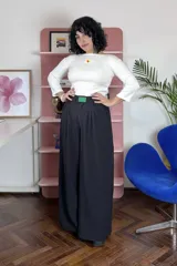Pantalón sastrero de corte amplio y tiro alto, confeccionado en viscosa. Presenta pinzas en la cintura y un aplique decorativo de acrílico en el centro de la pretina.
