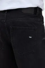 Bermuda de jean de corte relajado, con piernas holgadas, color negro desgastado.