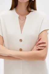 Blusa de viscosa color blanco, de corte holgado, con cuello en V y cierre frontal parcial de botones grandes con efecto carey.