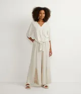 Blusa color crema con estampado animal print de jaguar en tonos dorados, escote en V, mangas 3/4 y nudo en la parte inferior.