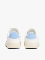 Zapatillas blancas de cuero con cordones, suela cupsole color crema y talón celeste.