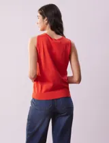 Musculosa tejida color naranja, de hilado fino y cuello redondo.