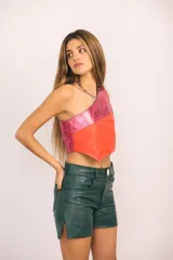 Shorts de cuero color verde de tiro medio y corte recto, con cierre frontal, botón y bolsillos funcionales.