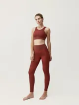 Top deportivo color ladrillo con estampado geométrico, de sujeción media-alta y tirantes cruzados en la espalda.