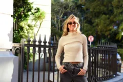 Polera de tejido acanalado color beige, de calce ajustado al cuerpo, con cuello alto y mangas largas.