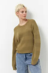 Sweater color borgoña de manga larga, tejido tramado y cuello redondo con puños elastizados.