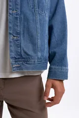 Campera de jean azul claro con bolsillos frontales con solapa y botones metálicos.