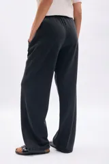 Pantalón deportivo ancho color negro con efecto lavado, cintura elástica con cordón ajustable y bolsillos laterales.