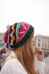 Gorro de lana tejido con diseño multicolor en patrones geométricos y étnicos, con borde acanalado en color verde oscuro.