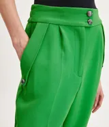 Pantalón zanahoria de vestir color verde, con cintura alta, bolsillos laterales con detalle de botones y corte sastrero.