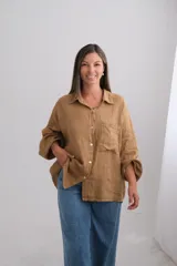 Camisa de lino italiano color tostado, con corte oversize, cuello clásico, cierre frontal con botones y mangas largas con puños elásticos.