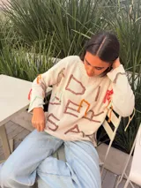 Sweater de algodón crudo tejido en punto jersey, con bordados artesanales en hilos de colores y diseño oversize.