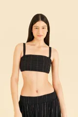 Top negro con volantes y pespuntes brillantes, escote cuadrado delante y detrás, tirantes con ajustadores y detalle de solapa en capas en el busto.