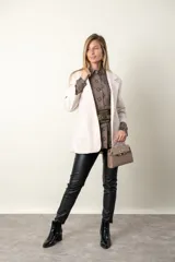 Blazer color crema de paño recto con cierre de un botón y dos bolsillos delanteros.