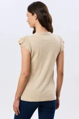 Remera tejida de algodón en color beige, de cuello redondo, sin mangas y con detalles de volados estructurados en los hombros.