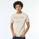 Camiseta beige de manga corta con estampado frontal con texto "New York" y dirección.
