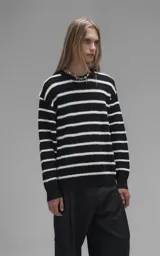 Sweater de cuello redondo con diseño de rayas horizontales en blanco y negro. Confeccionado en tejido de punto con textura suave, corte oversize y terminaciones en punto rib en cuello, puños y ruedo.