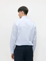 Camisa de vestir celeste de manga larga con cuello italiano y cierre frontal de botones.
