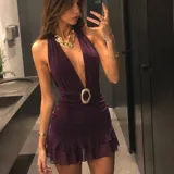 Vestido corto color morado de microtul con doble tela y short incluido, diseño sin mangas, escote halter pronunciado y detalle de hebilla brillante en la cintura.