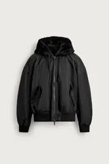Cazadora bomber reversible de corte relaxed fit confeccionada en tejido técnico color negro, con capucha ajustable con interior de efecto pelo, bolsillos en la cadera, rib elástico en puños y cintura, y cierre frontal con cremallera de doble dirección.