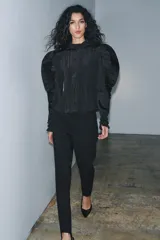 Blusa negra de cuello alto y manga larga abullonada con puños abotonados. Tejido arrugado y cierre frontal oculto con botones. Zara Woman Collection.