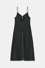 Top largo confeccionado en lino, color negro, con tirantes finos, escote en V con encaje y detalle de frunces y lazada frontal.