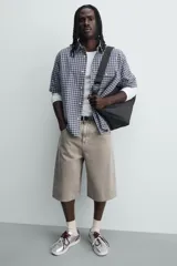 Bolso de hombro tipo hobo fabricado en tejido técnico de nylon. Cuenta con un compartimento principal con cierre de cremallera, un bolsillo interior con cierre y un asa ajustable con detalle de mosquetón.
