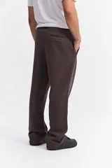 Pantalón de algodón de corte recto y estilo relajado, color beige. Cuenta con cintura elástica con cordón de ajuste, bolsillos laterales y logo de la marca estampado discretamente en el frente.