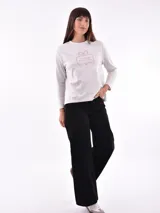 Remera de manga larga color crema con cuello redondo y un estampado central de un ramo de flores rosadas y naranjas en un jarrón azul oscuro.