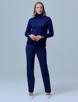 Polera de tejido fino, color rosado, con cuello alto, manga larga y detalle de tajo en los puños.